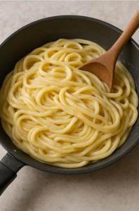mixing creamy sauce with pasta